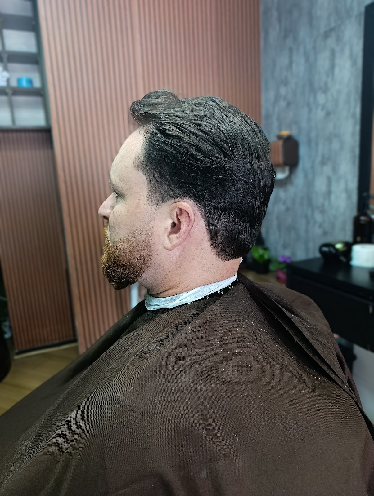 Cliente com o corte finalizado, na barbearia A Barbeira